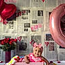 Ayla joined the competition — help win amazing prizes! baby, pink_bow, pink_clothing, wooden_crate, blanket, balloons, heart_shaped, roses, cupcakes, chocolate_strawberries, newspaper_wall, love_notes, hearts, smiling, happy, indoor, decorations, cute, child, portrait