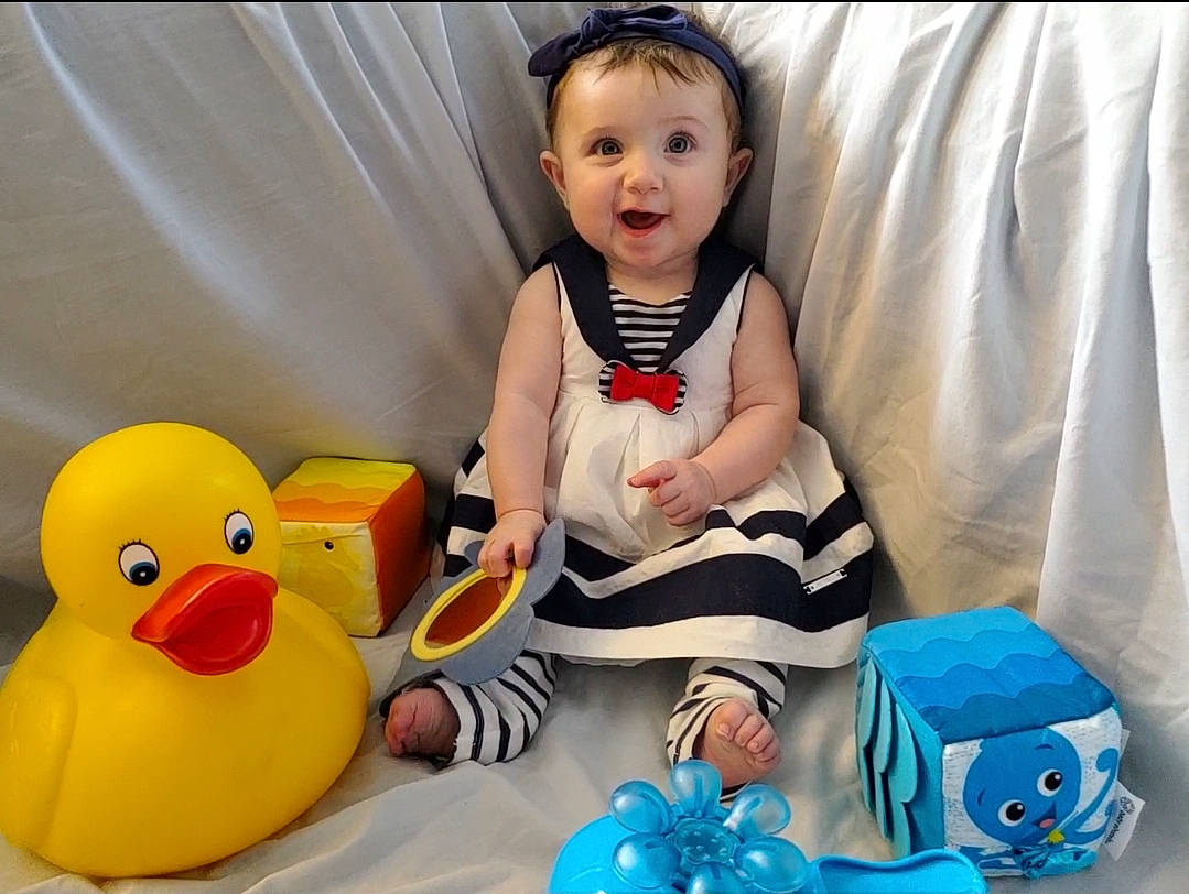 Lilith is registered to the contest to win money with this photo: _geese_and_swans, baby, baby_playing_with_toys, baby_toddler_clothing, bath_toy, beak, blue, ducks, fun, happy, head, organ, person, product, rubber_ducky, sleeve, smile, toddler, toy, waterfowl