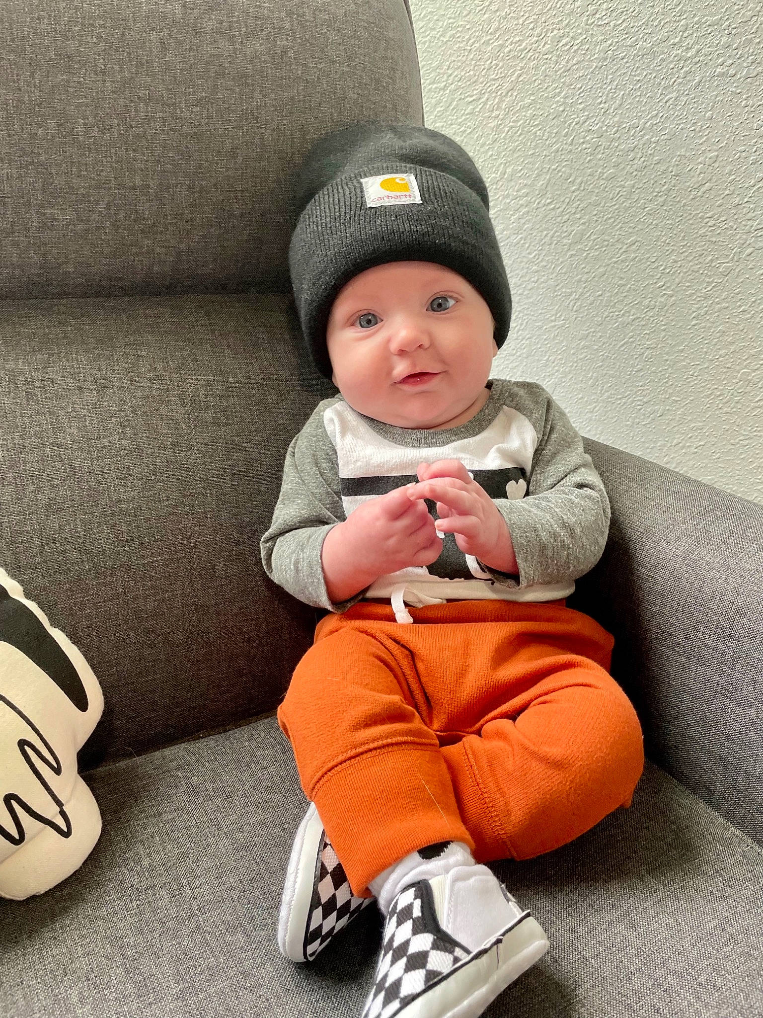 Case is registered to the contest to win money with this photo: baby, baby_toddler_clothing, cap, child, comfort, headgear, headwear, human_leg, knee, knit_cap, lap, leg, outerwear, pattern, person, sitting, sleeve, smile, sock, thigh