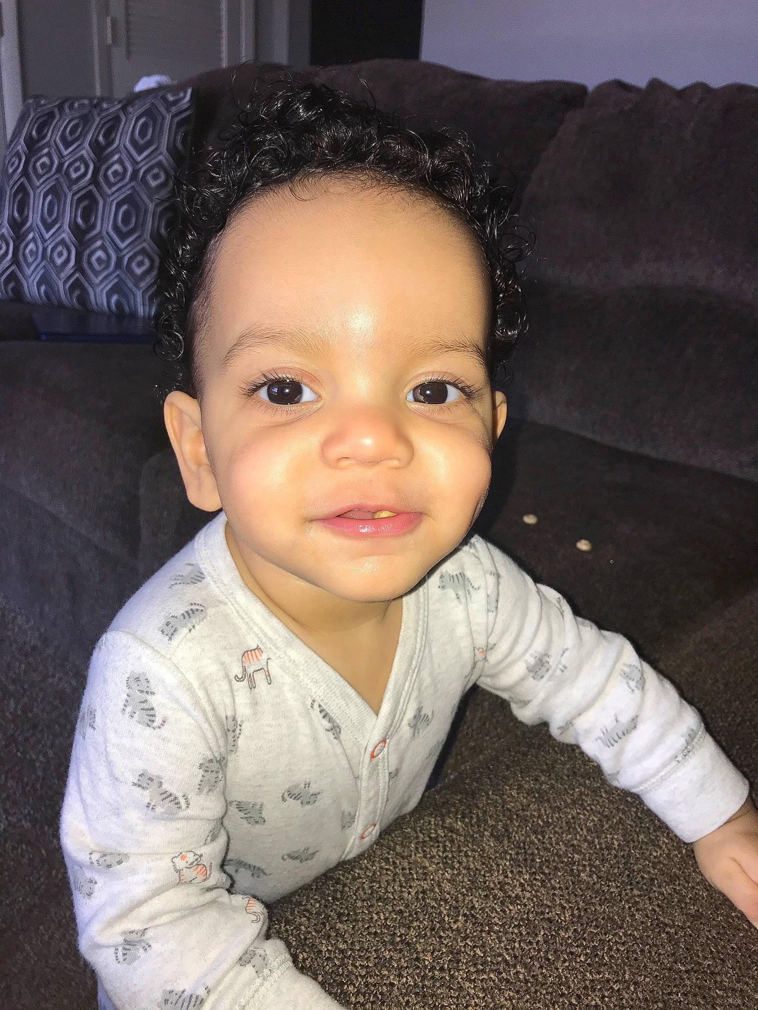 Zaccai is registered to the contest to win money with this photo: baby, black_hair, cheek, child, chin, eye, face, facial_expression, forehead, hair, hairstyle, head, iris, lip, nose, person, sitting, skin, smile, toddler