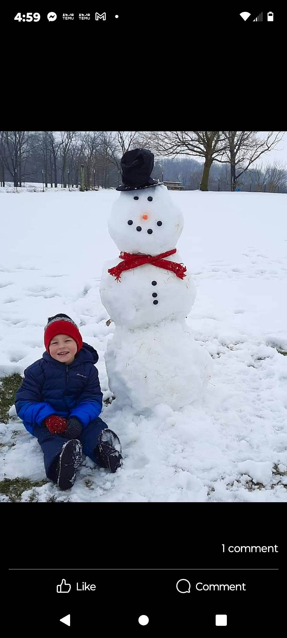 Remington is registered to the contest to win money with this photo: baby_toddler_clothing, electric_blue, event, freezing, happy, headwear, joy, person, playing_in_the_snow, precipitation, recreation, smile, snow, snowman, toddler, tree, under_exposed, white, winter