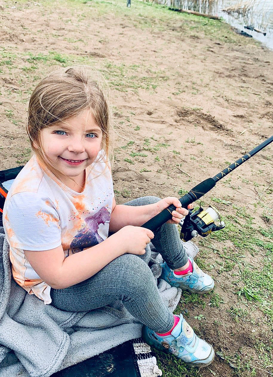 Kora is registered to the contest to win money with this photo: angling, child, fishing_reel, fishing_rod, fun, grass, grass_family, grassland, happy, joy, leisure, outdoor_recreation, people_in_nature, person, play, recreation, shoe, sitting, smile, sneakers