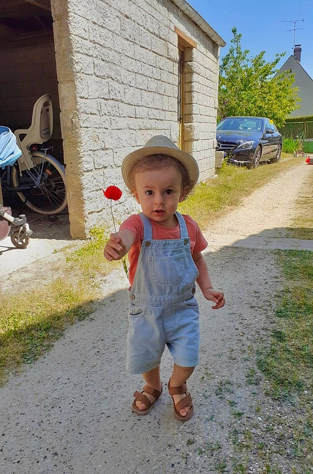 Sol participe au concours pour gagner de l'argent avec cette photo : asphalt, bicycle_wheel, child, concrete, fun, grass, hat, house, landscape, leg, leisure, person, plant, recreation, sky, sun_hat, surprise, tire, toddler, tree