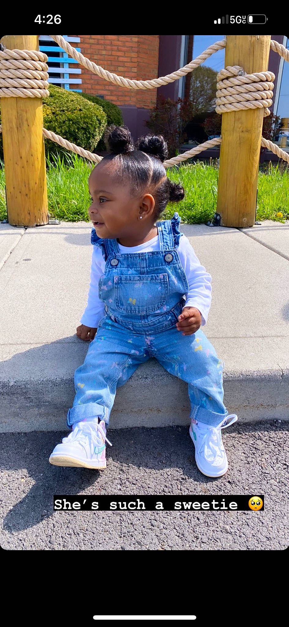 Zoella is registered to the contest to win money with this photo: asphalt, baby, baby_toddler_clothing, child, denim, electric_blue, face, grass, happy, head, leisure, morning, person, plant, public_space, road_surface, sitting, sleeve, sneakers, t_shirt