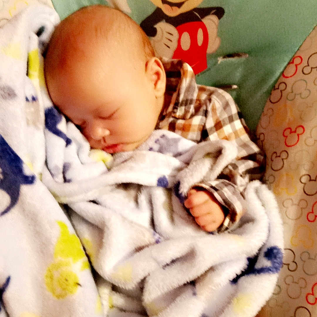 Hunter joined the competition — help win amazing prizes! baby, bedtime, blanket, cartoon_character, child, comfort, cozy, cute, indoor, infant, mickey_mouse, nap, patterned_fabric, peaceful, plaid_shirt, rest, sleeping, soft_toy_pattern, striped_sock, toddler