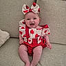 Elise participe au concours pour gagner de l'argent avec cette photo : baby, child, smiling, sitting, couch, indoor, headband, bow, red, white, heart_pattern, clothing, happy, cute, infant, person, fabric, skin, legs, photography
