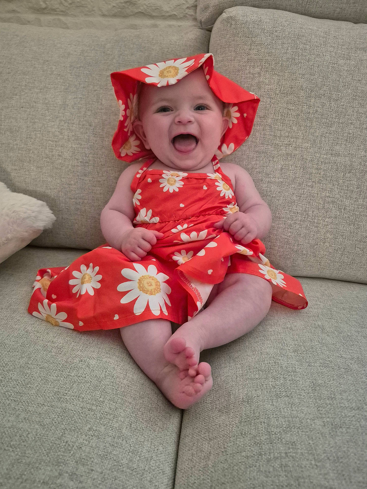Elise a rejoint le concours — aidez-le/la à gagner de superbes lots ! baby, child, couch, cute, dress, face, feet, flower_pattern, furniture, hands, happy, hat, indoor, infant, living_room, portrait, red_clothing, sitting, skin, smiling