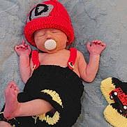Cannon is registered to the contest to win money with this photo: adorable, baby, blanket, child, cozy, cute, fire_truck, handmade, indoors, infant, knit_clothing, newborn, pacifier, peaceful, red_hat, resting, sleeping, small, soft_texture, toy
