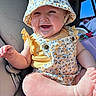 baby, car_seat, child, clothing, cute, floral, foot, hand, happy, hat, infant, interior, overalls, person, portrait, seatbelt, skin, smile, sunlight, window
