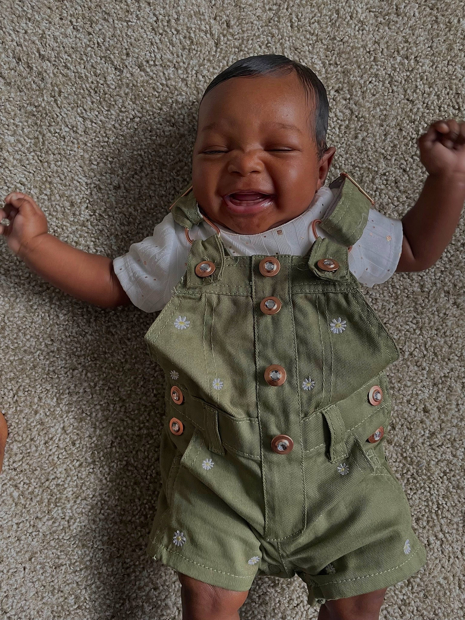 Harlem is registered to the contest to win money with this photo: baby, baby_toddler_clothing, cheek, child, collar, face, facial_expression, finger, gesture, happy, head, neck, nose, pattern, person, skin, sleeve, smile, standing, t_shirt
