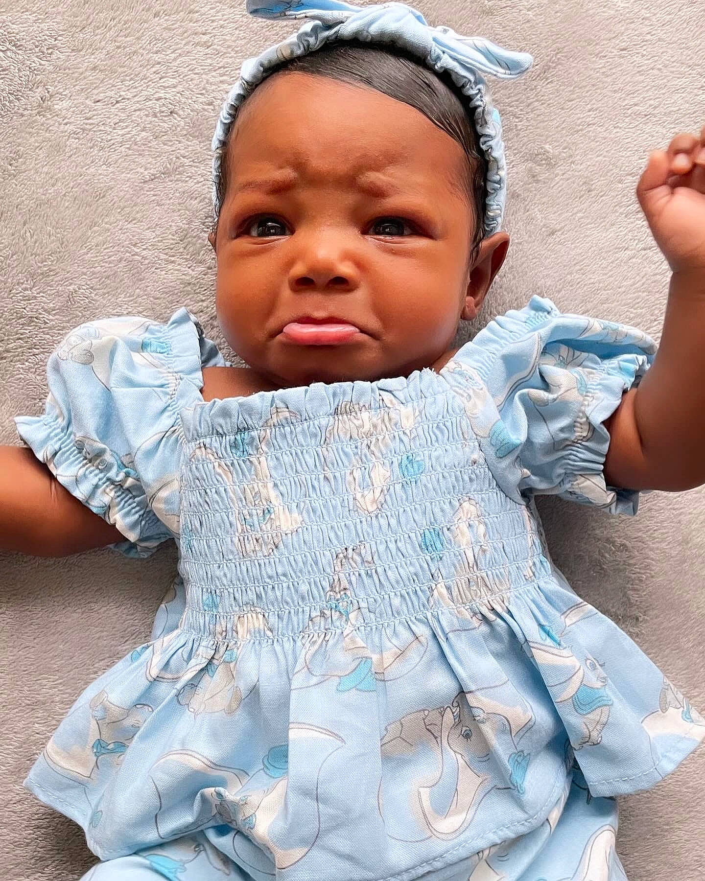 Harlem is registered to the contest to win money with this photo: azure, baby_toddler_clothing, blue, dress, eye, eyelash, face, happy, headgear, iris, lip, mouth, neck, person, pink, skin, sleeve, textile, toddler, tradition