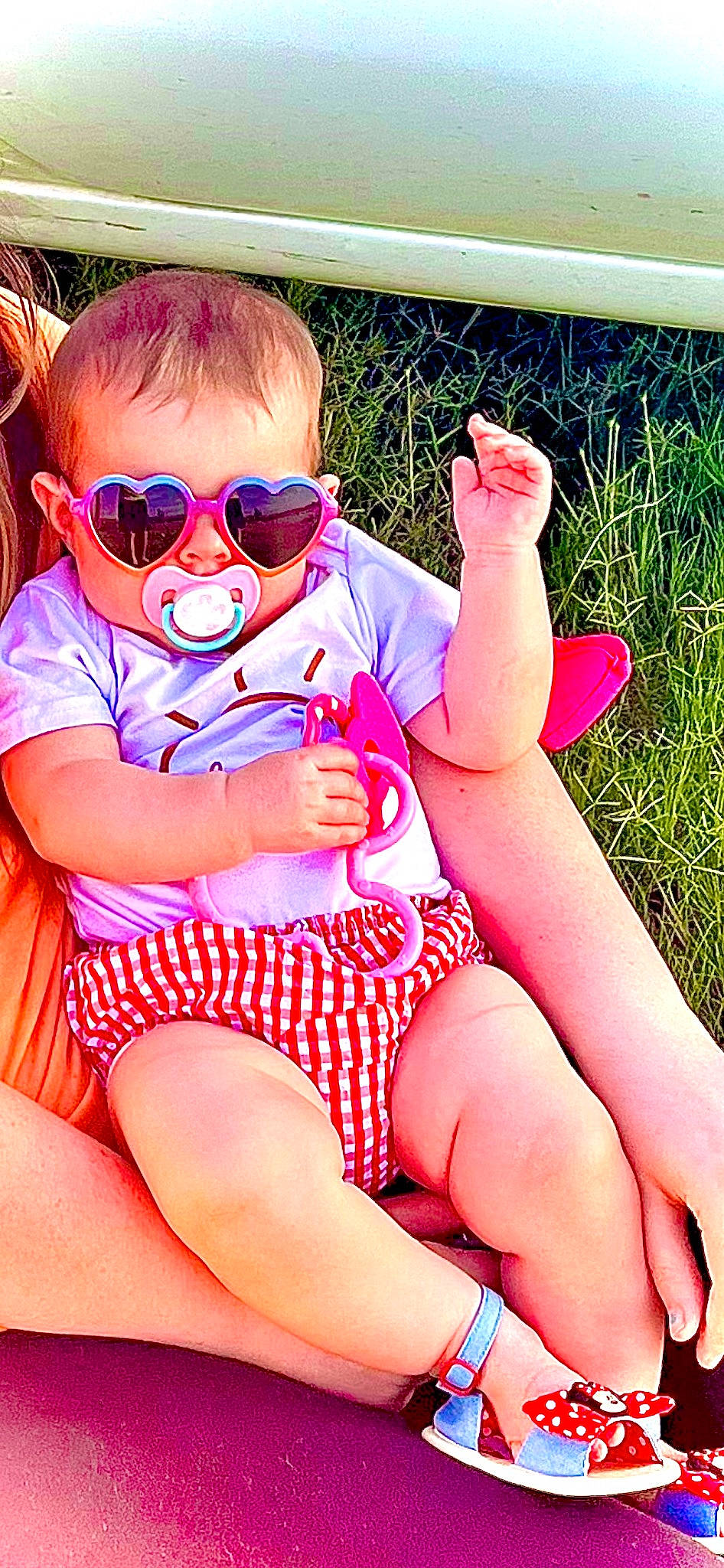 Oakleigh is registered to the contest to win money with this photo: baby_toddler_clothing, eyewear, finger, goggles, grass, happy, knee, lap, leg, leisure, mouth, person, pink, shorts, skin, summer, sunglasses, thigh, thumb, toddler
