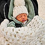 baby, infant, sleeping, hat, knitted_hat, pom_pom, blanket, crochet_blanket, hoodie, green_clothing, car_seat, child, face, peaceful, indoors, cozy, warm, newborn, clothing, cute