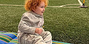 Madilynn joined the competition — help win amazing prizes! toddler, child, red_hair, gray_tracksuit, sneakers, indoor_soccer_field, artificial_turf, sports, playing, mat, striped_mat, stadium_lights, people, sports_activity, seating_area, green_turf, smiling, casual_clothing, athletic_shoes, recreation