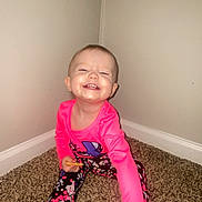 Gracelynn is registered to the contest to win money with this photo: toddler, child, smiling, happy, sitting, carpet, corner, long_sleeve, leggings, shoe, indoor, person, cute, playful, young_child, fashion, colorful, wall, floor, feet