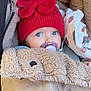 baby, pacifier, red_hat, blanket, fleece, stroller, infant, cozy, cute, warm_clothing, blue_eyes, child, portrait, wrapped, winter_wear, headwear, closeup, sitting, soft_texture, outdoor