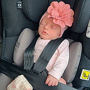 Elya participe au concours pour gagner de l'argent avec cette photo : baby, blanket, car_seat, child, clothing, comfort, cute, flower_headband, hand, headwear, indoors, infant, pink, rest, safety_harness, seat, sleeping, soft, strap, toddler