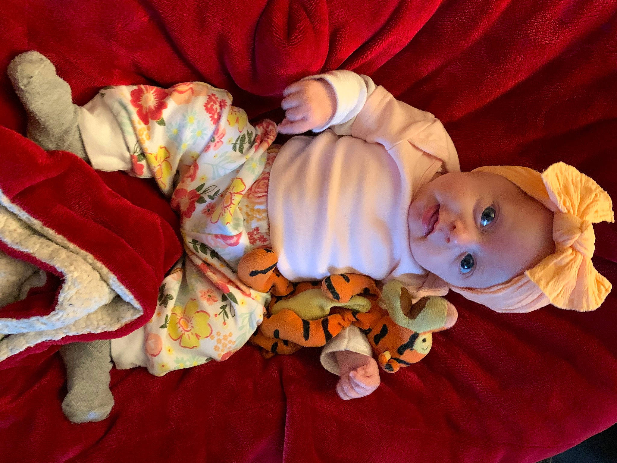 Gemma is registered to the contest to win money with this photo: arm, baby, baby_products, baby_toddler_clothing, carmine, child, comfort, flooring, happy, hat, head, headwear, lap, linens, mammal, orange, person, sitting, smile, toddler