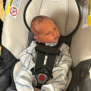 Liam is registered to the contest to win money with this photo: newborn, baby, infant, child, car_seat, harness, safety, seated, portrait, face, eyes_open, striped_clothing, onesie, indoors, vehicle, infant_carrier, cushioned_seat, looking_away, photograph, safe