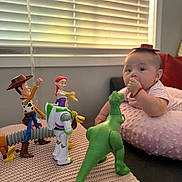 Zoey joined the competition — help win amazing prizes! baby, toy_story, woody, jessie, buzz_lightyear, rex, toy_figures, pink_cushion, window_blinds, indoor, child, soft_texture, playtime, curious, red_bracelet, hat, lying_down, plastic_toys, colorful, home
