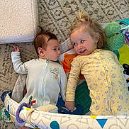 Cosmo is registered to the contest to win money with this photo: baby, child, play_mat, onesie, toy, carpet, floor, infant, smile, lying_down, cute, indoor, happy, toddler, foot, blanket, colorful, patterned, face, person