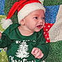 Christian joined the competition — help win amazing prizes! baby, child, santa_hat, christmas, holiday, festive, green_shirt, patterned_pants, patchwork_quilt, smiling, happy, infant, cute, holiday_clothing, red_hat, white_fur_trim, colorful_background, portrait, indoors, celebration