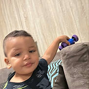 Adam a rejoint le concours — aidez-le/la à gagner de superbes lots ! child, boy, toy, car, couch, cushion, indoor, furniture, curtains, clothing, pattern, holding, playing, smiling, portrait, young, person, home, casual, blurred