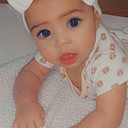 Addyson is registered to the contest to win money with this photo: baby, infant, bow, headband, blanket, cute, eyes, face, expression, hand, skin, clothing, pattern, lying_down, soft_texture, indoors, portrait, adorable, child, young