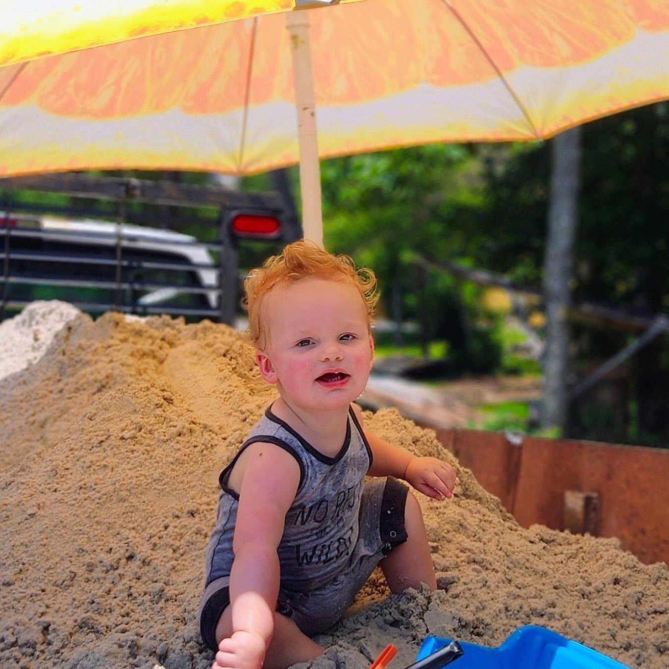 Bobby Ray joined the competition — help win amazing prizes! blue_bucket, bucket, child, curly_hair, fun, happy, nature, outdoor, play, sand, sand_pile, shovel, smiling, summer, summer_clothes, sunny, toddler, toy_truck, umbrella, yellow_umbrella