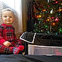 Bobby Ray is registered to the contest to win money with this photo: child, toddler, pajamas, plaid, red, christmas_tree, decorations, ornaments, lights, holiday, indoor, window_blinds, smile, face, sitting, cozy, festive, home, curious, cute