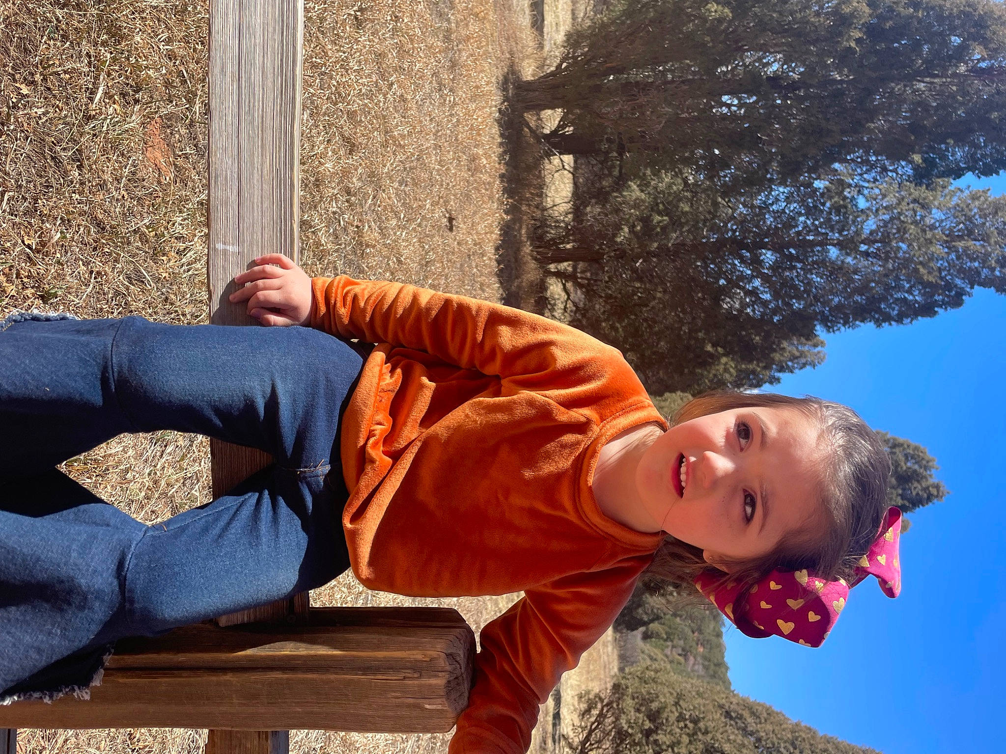 Allie joined the competition — help win amazing prizes! arm, child, denim, electric_blue, eyewear, fun, grass, happy, human_leg, knee, leisure, orange, people_in_nature, person, sitting, sky, thigh, tree, wood