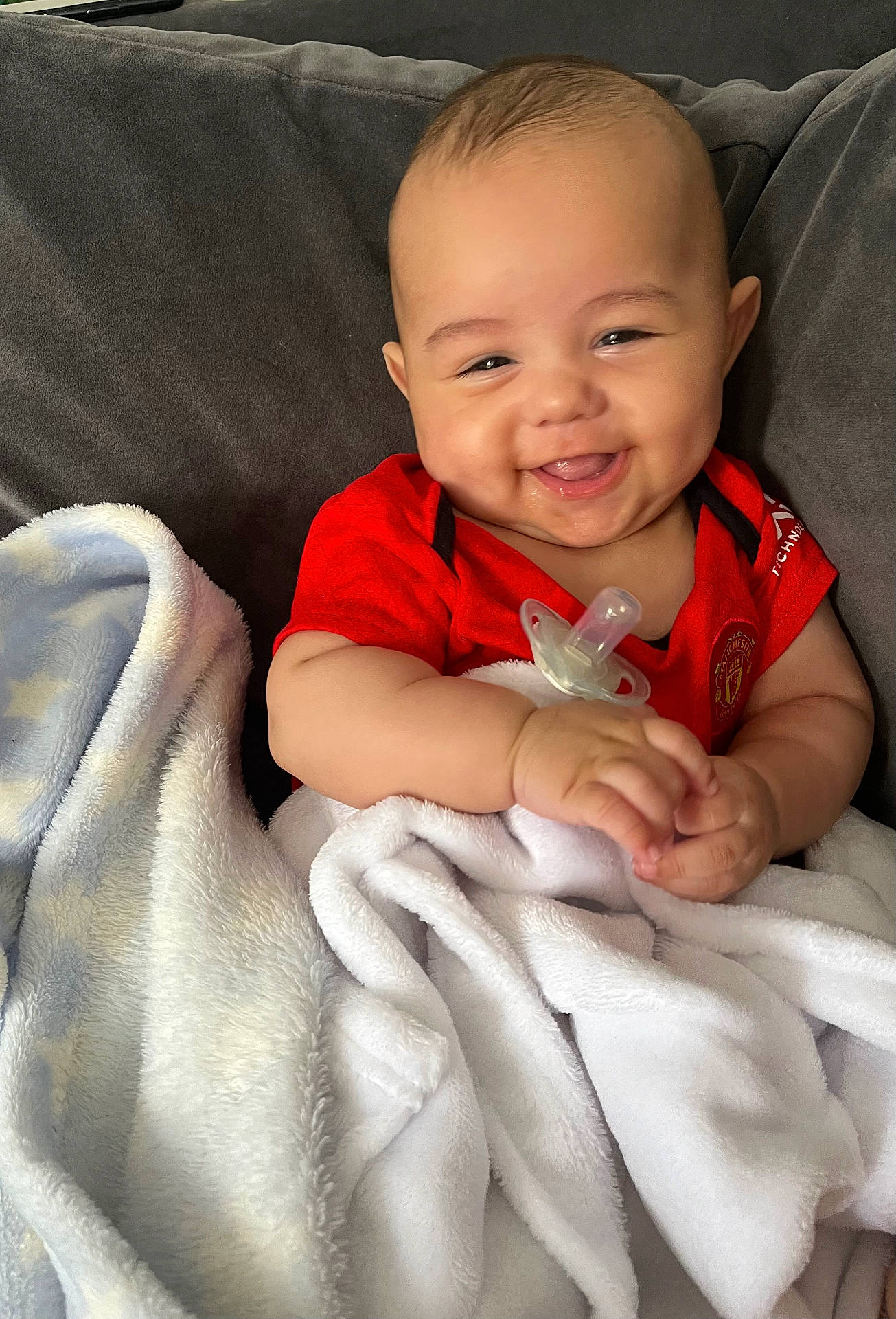 Kylo is registered to the contest to win money with this photo: baby, bed, blanket, bodypart, couch, cushion, face, finger, furniture, hand, happy, head, homedecor, laughing, newborn, person, photography, portrait, quilt, smile