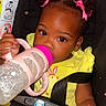 Azaria joined the competition — help win amazing prizes! toddler, child, baby, car_seat, bottle, pink_bow, yellow_dress, drink, cute, face, hair, sitting, seatbelt, infant, portrait, indoor, happy, holding, closeup, adorable
