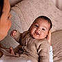 Aylan participe au concours pour gagner de l'argent avec cette photo : baby, child, woman, holding, knitted_clothing, smiling, face, portrait, indoor, cozy, warm_tones, soft_texture, happy, person, couch, blanket, family, care, love, comfort