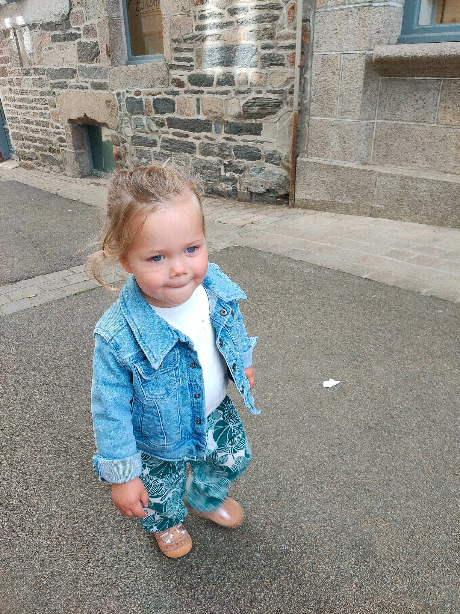 Yaëlle a rejoint le concours — aidez-le/la à gagner de superbes lots ! asphalt, baby_toddler_clothing, brick, child, chin, denim, electric_blue, flooring, fun, grass, leisure, pattern, person, road, road_surface, sidewalk, sitting, street_fashion, toddler, travel