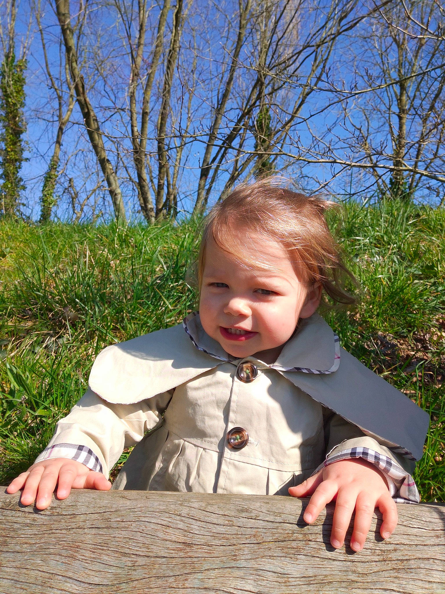 Yaëlle a rejoint le concours — aidez-le/la à gagner de superbes lots ! baby, baby_toddler_clothing, blond, child, fun, grass, grass_family, happy, leaf, leisure, people, people_in_nature, person, plant, sitting, skin, sky, toddler, tree, wood