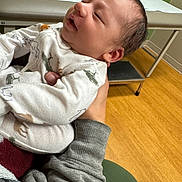 Logan joined the competition — help win amazing prizes! arms, baby, casual, clothing, cute, face, floor, hand, holding, indoors, infant, medical_table, newborn, person, portrait, room, sleepy, sleeve, warm, young