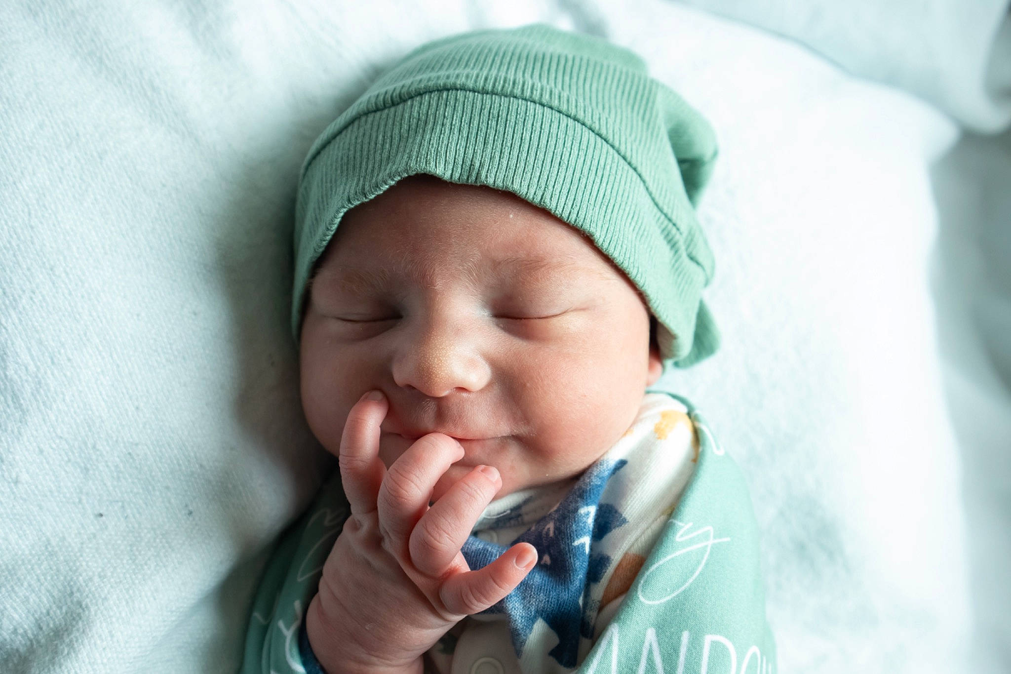 Landon is registered to the contest to win money with this photo: azure, baby, cap, cheek, child, chin, comfort, eyebrow, finger, gesture, happy, headgear, headwear, lip, mouth, neck, nose, outerwear, person, skin