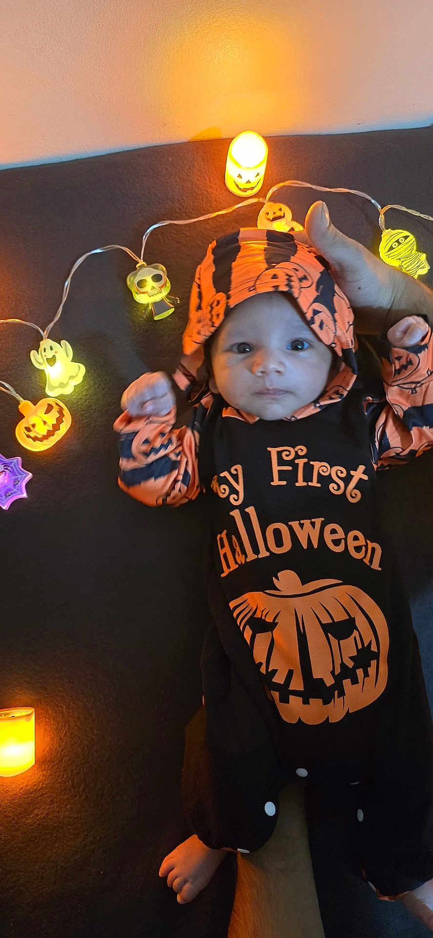Nivaan joined the competition — help win amazing prizes! baby, infant, halloween, costume, orange, black, lights, string_lights, pumpkin, ghost, skull, mummy, hand, foot, celebration, holiday, cute, indoors, festive, child