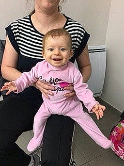 Angéline a rejoint le concours — aidez-le/la à gagner de superbes lots ! baby, baby_products, baby_toddler_clothing, cheek, child, fun, gesture, happy, jewellery, joy, magenta, pattern, person, pink, purple, room, sitting, sleeve, smile, t_shirt