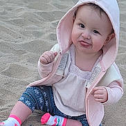 Nayley joined the competition — help win amazing prizes! baby, child, sand, hoodie, pink, socks, leggings, playful, tongue_out, cute, outdoor, sitting, smiling, face, person, clothing, casual, young_child, happy, funny_expression