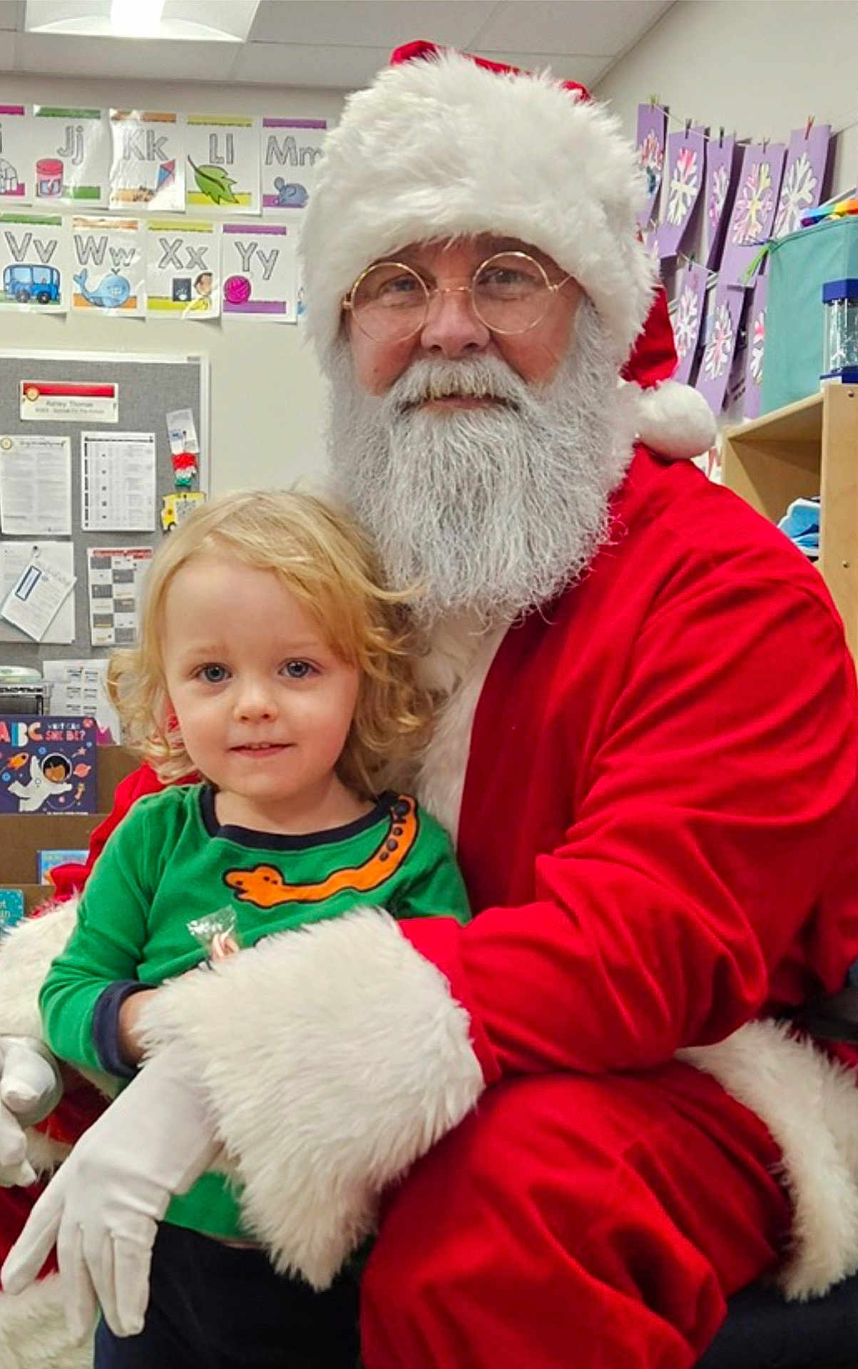 Axton joined the competition — help win amazing prizes! child, santa_claus, holiday, christmas, classroom, festive, beard, red_suit, glasses, smile, blonde_hair, curly_hair, young_child, person, indoor, education, alphabet_cards, decorations, gloves, happy