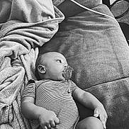 Major is registered to the contest to win money with this photo: baby, blanket, comfort, couch, face, hand, head, home, indoor, infant, lying_down, monochrome, pacifier, peaceful, person, relaxation, small_hands, soft_texture, striped_clothing, young_child