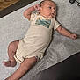 Luke joined the competition — help win amazing prizes! arm, baby, casual, child, clothing, curious, cute, diaper, dinosaur_onesie, face, healthcare, indoors, infant, leg, lying_down, medical_table, newborn, paper_cover, person, skin
