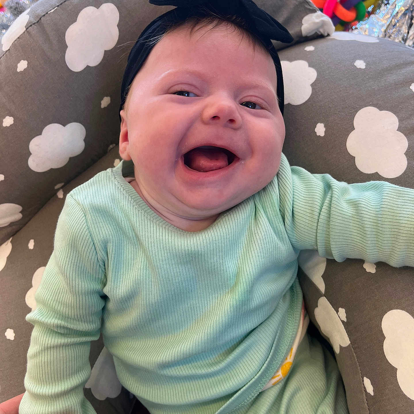 Dolcie-Mai is registered to the contest to win money with this photo: accessories, baby, babylaughing, bodypart, clothing, couch, cushion, face, furniture, happy, head, homedecor, laughing, mouth, person, photography, portrait, smile, t_shirt, teeth