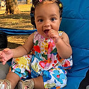 Leilani joined the competition — help win amazing prizes! toddler, child, outdoor, blue_chair, colorful_clothing, flower_hair_clips, smiling, happy, sitting, summer, sunlight, shoes, bare_arms, curly_hair, nature, grass, tree, playful, portrait, cute