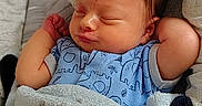 Landon is registered to the contest to win money with this photo: newborn, baby, sleeping, blanket, blue_onesie, elephant_pattern, arms_up, cozy, soft_texture, infant, cute, resting, indoor, portrait, child, peaceful, closeup, face, head, comfort