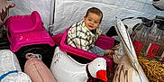 Kingsley a rejoint le concours — aidez-le/la à gagner de superbes lots ! child, toddler, toy_wagon, inflatable_animals, pink, plaid_jacket, grass, tent, indoor, play, smiling, cute, farm_animals, inflatable_sheep, inflatable_pig, inflatable_goose, happy, casual_clothing, bottle, hay