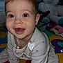 baby, infant, smiling, crawling, pajamas, star_pattern, play_mat, colorful, teddy_bear, toy, indoor, child, cute, happy, face, person, young_child, cozy, expression, home
