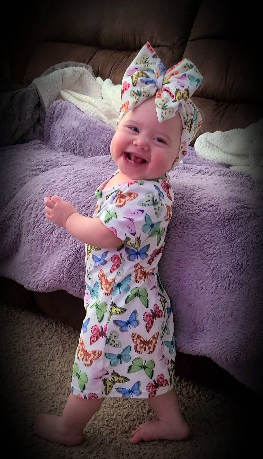 Echo is registered to the contest to win money with this photo: baby, baby_toddler_clothing, child, comfort, cool, dress, eye, face, happy, head, headgear, headwear, human_body, joy, person, pink, purple, skin, sleeve, smile